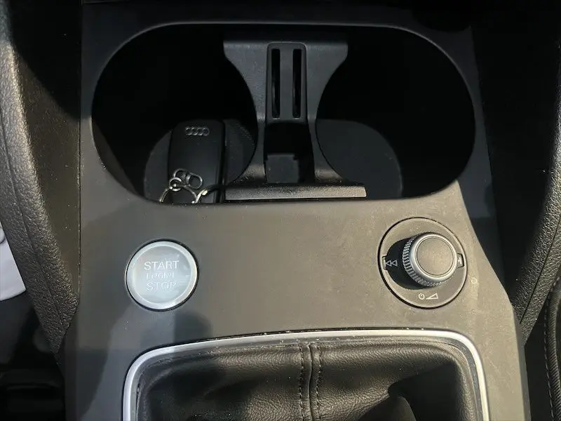 Gros plan sur la console centrale de l'Audi Q2 bleu Navarre 2021, avec bouton start/stop et molette de contrôle.