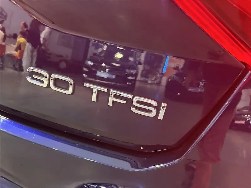 Gros plan sur l'arrière bleu Navarre métal d'un Audi Q2 30 TFSI 2021 avec badge moteur visible et feu arrière rouge.