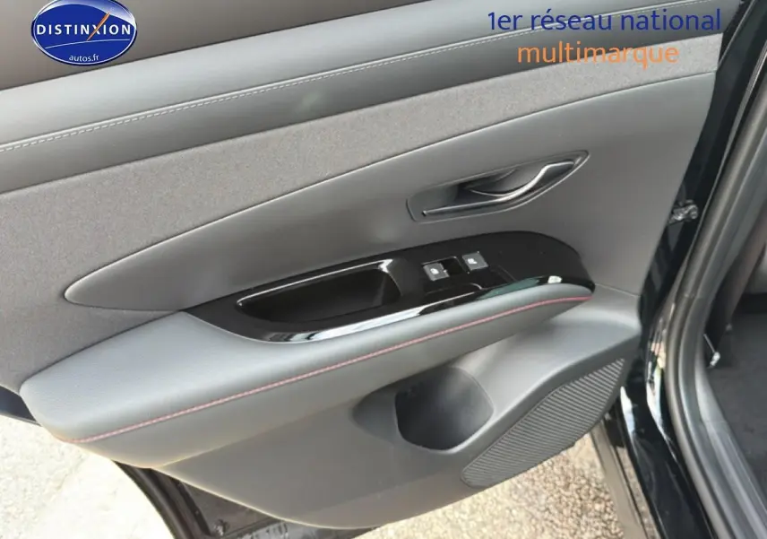 Gros plan sur la porte avant gauche noire du Hyundai Tucson 2026 avec commandes de vitres et poignée intégrée.