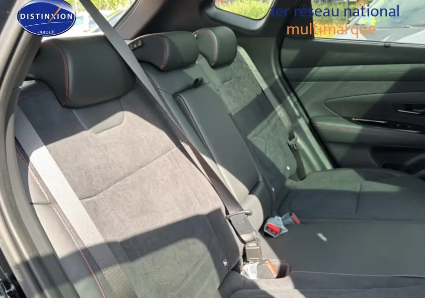 Vue latérale droite des sièges arrière noirs en cuir et alcantara avec surpiqûres rouges du Hyundai Tucson 2026 hybride N Line Executive.