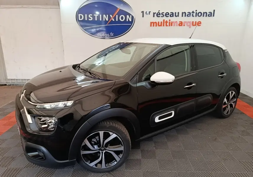 Citroën C3 PureTech 110 noir vue 3/4 avant droit avec toit et rétroviseurs blancs en intérieur showroom.
