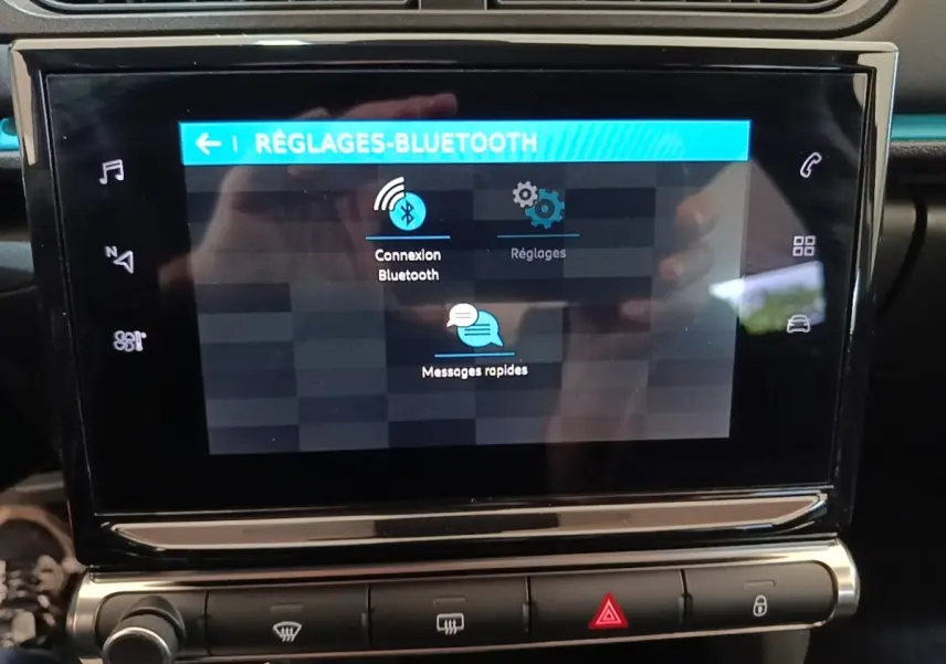 Écran tactile central de la Citroën C3 noire 2022 affichant les réglages Bluetooth en vue frontale rapprochée.