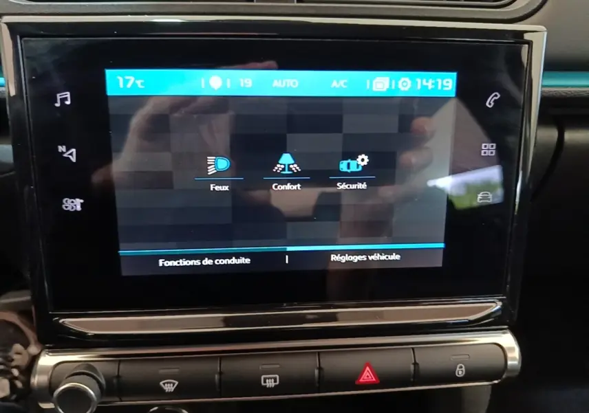 Écran tactile central de la Citroën C3 noire, affichant les réglages feux, confort et sécurité, vue rapprochée intérieure.
