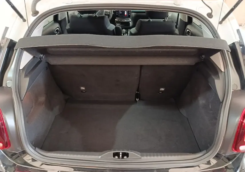 Coffre ouvert vu de l'arrière d'une Citroën C3 noire 2022, intérieur du coffre et sièges arrière visibles.
