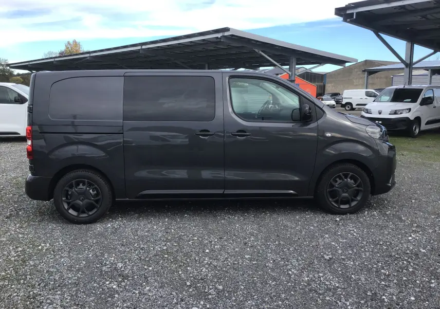 Profil côté gauche d'un Citroën Jumpy Cabine Approfondie gris titane, avec jantes noires et vitres teintées.