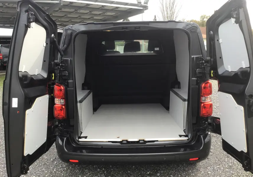 Vue arrière du Citroën Jumpy gris titane avec portes ouvertes montrant un espace de chargement aménagé en bois clair.