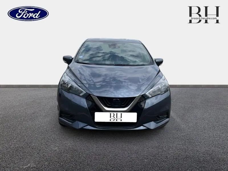 Vue de face d'une Nissan Micra gris acier 2022 avec calandre noire et phares anguleux.