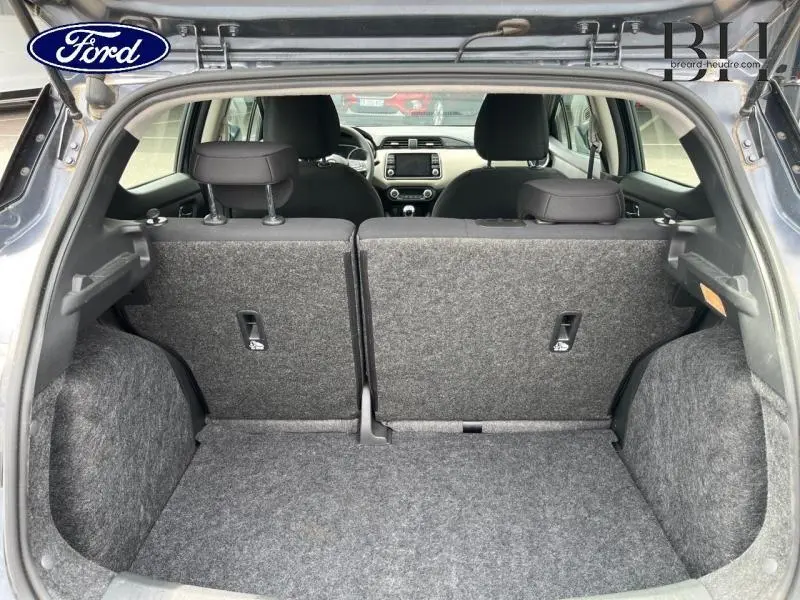 Coffre ouvert d'une Nissan Micra gris acier vue arrière, banquette arrière en tissu bi-ton noir et gris.