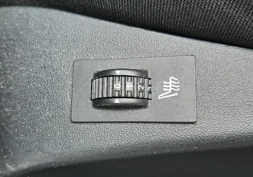 Réglage du chauffage de siège en gros plan sur une commande noire dans l'habitacle du Peugeot 2008 blanc de 2017