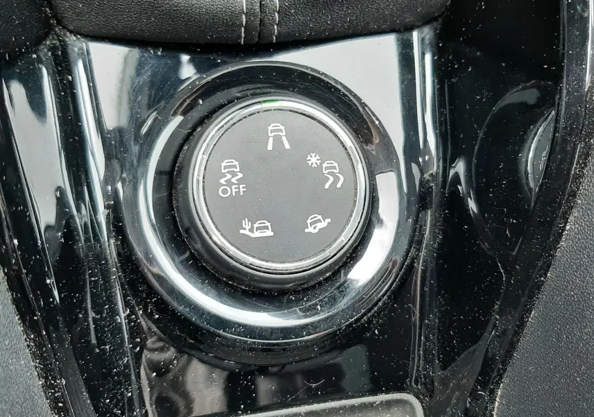 Gros plan sur le sélecteur de modes de conduite noir brillant dans l'habitacle du Peugeot 2008 blanc de 2017.