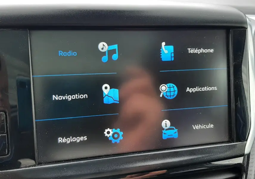 Écran tactile central du tableau de bord du Peugeot 2008 2017 affichant les menus radio, téléphone, navigation, applications, réglages et véhicule.