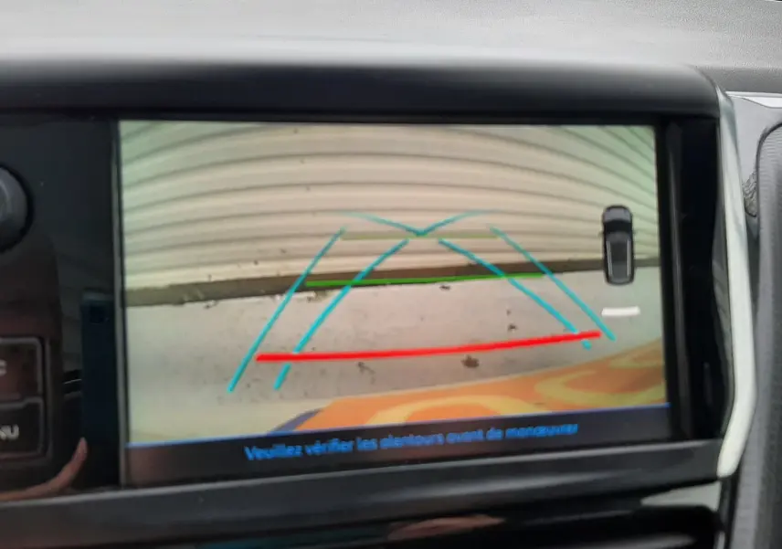 Écran de caméra de recul du Peugeot 2008 blanc montrant les lignes de guidage colorées en bleu et rouge.