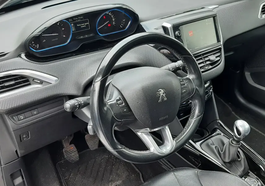 Intérieur noir du Peugeot 2008 2017, vue du poste de conduite avec volant cuir et levier de vitesse manuel.