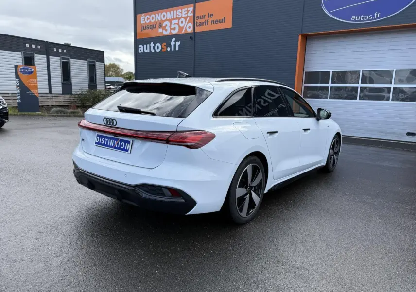 Audi A5 Avant blanc glacier métallisé vue 3/4 arrière droit avec vitres surteintées et jantes noires distinctives