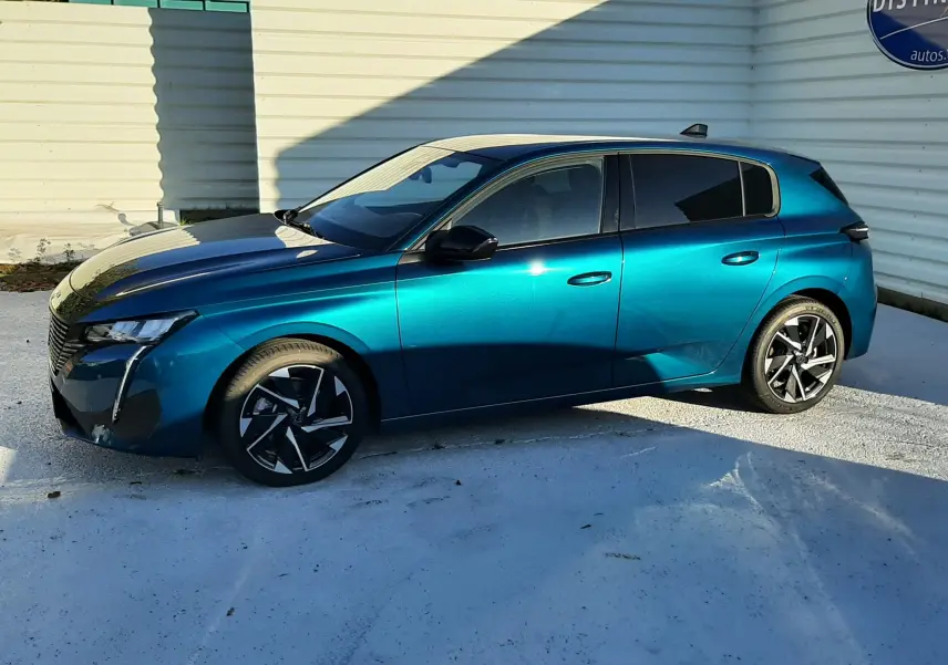 Peugeot 308 Bleu Obsession vue de profil côté gauche, avec jantes noires et design moderne sous un ciel dégagé.