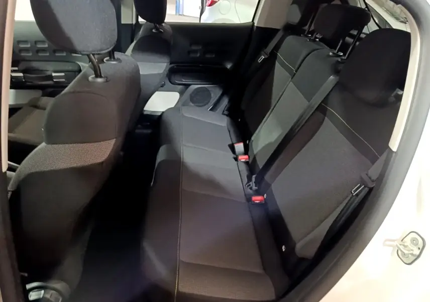 Vue intérieure côté droit montrant la banquette arrière noire de la Citroën C3 blanche 2023 PureTech Shine.