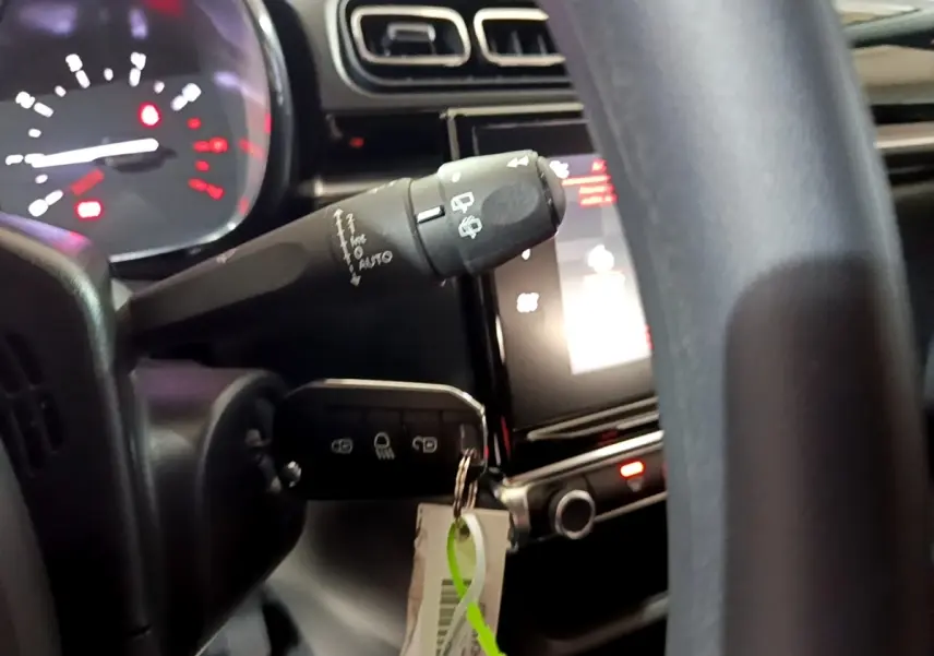 Gros plan sur le volant et le tableau de bord tactile de la Citroën C3 blanche, version PureTech 83 Shine 2023.