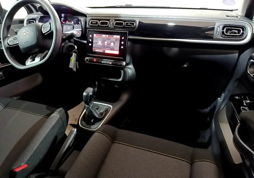 Intérieur noir de la Citroën C3 PureTech 83 Shine 2023, vue du poste de conduite avec écran tactile central.