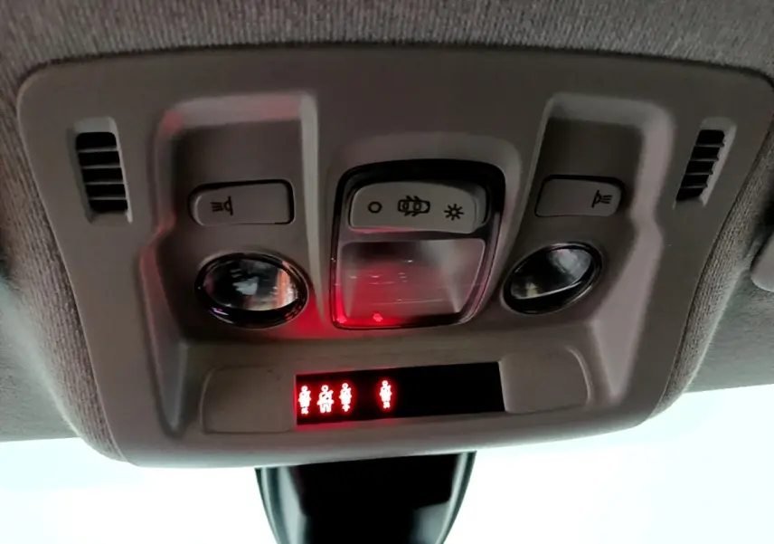 Vue en gros plan du plafonnier intérieur de la Citroën C3 blanche 2023 avec témoins de ceinture allumés.