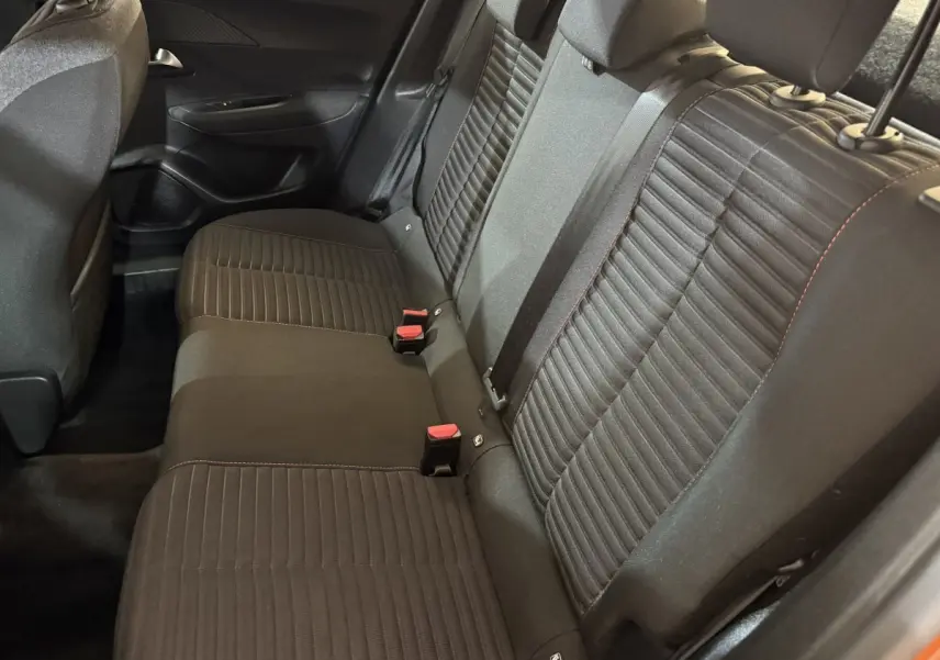 Vue intérieure sur la banquette arrière noire du Peugeot 2008 orange, montrant les sièges avec ceintures et appuie-têtes.