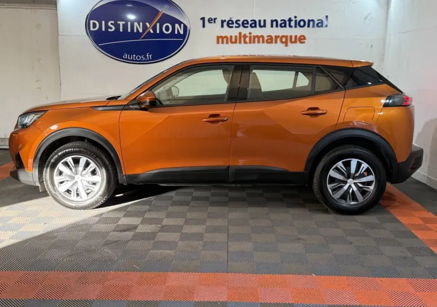 Profil droit d'un Peugeot 2008 orange 2022 avec jantes alliage et détails noirs contrastants sur les bas de caisse.