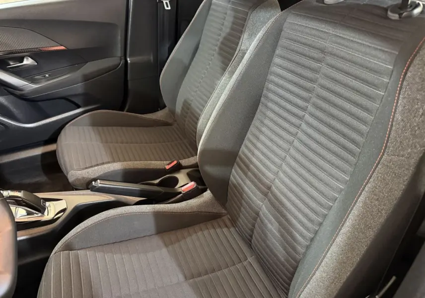 Vue intérieure côté droit des sièges avant gris foncé avec surpiqûres orange dans une Peugeot 2008 2022.
