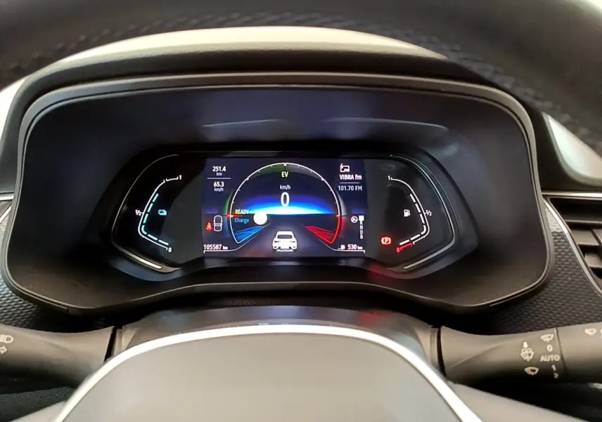 Vue rapprochée du combiné d'instruments numérique du Renault Arkana gris clair, affichant la vitesse et l'autonomie.