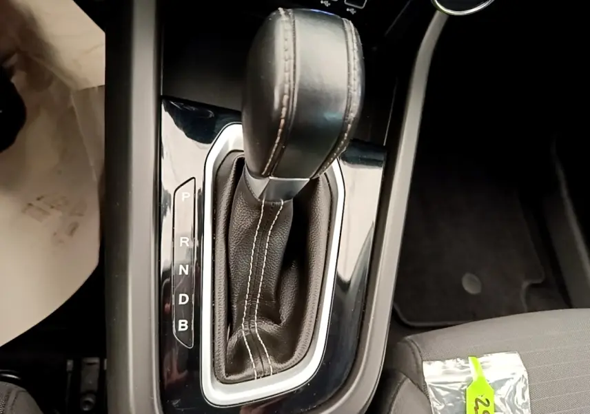 Le levier de vitesses automatique en cuir noir du Renault Arkana Evolution E-Tech, vue rapprochée de la console centrale.