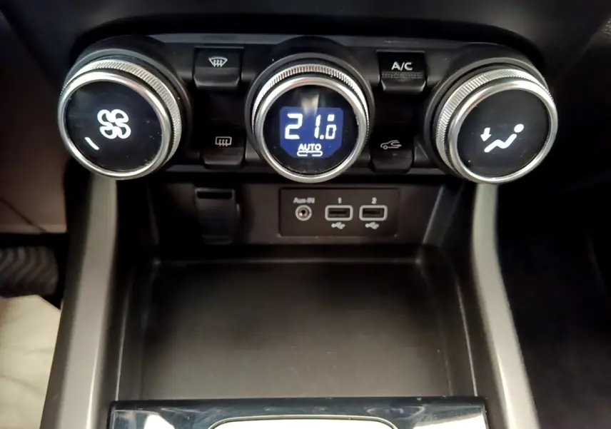Vue rapprochée des commandes de climatisation et des ports USB du Renault Arkana gris clair Evolution E-Tech 2023.