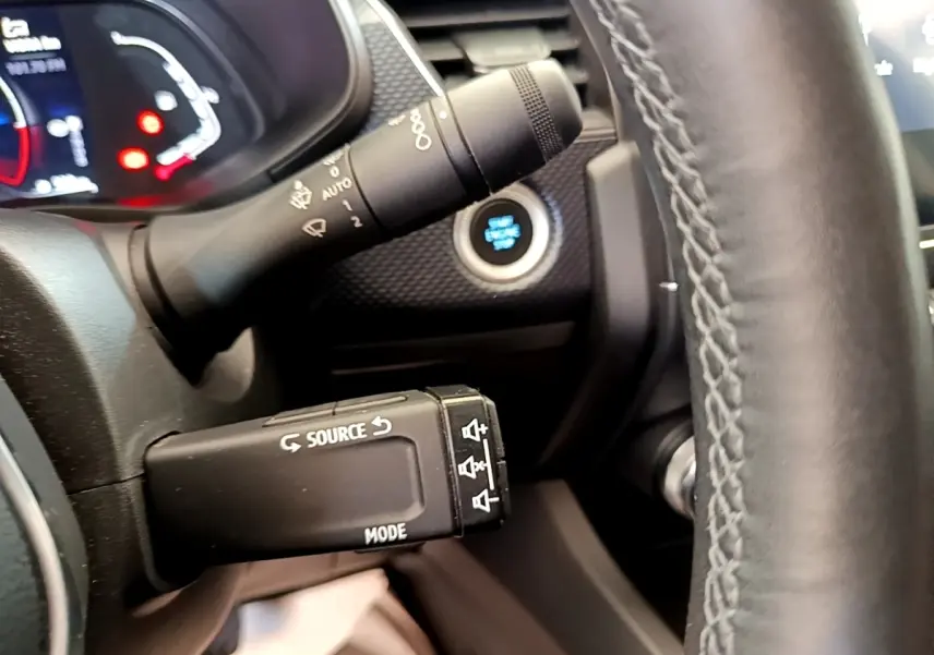 Gros plan sur la commande multifonctions côté gauche du volant en cuir noir du Renault Arkana gris clair.