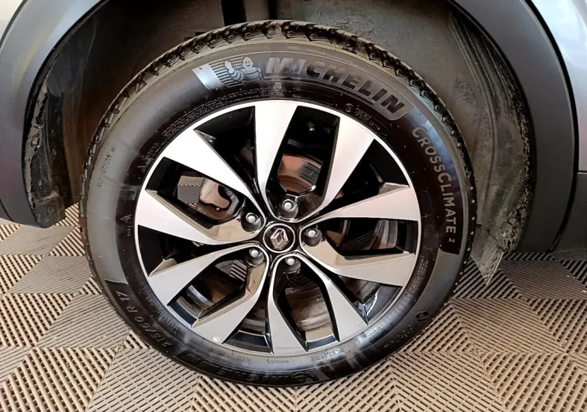 Gros plan sur la roue avant droite gris clair du Renault Arkana 2023 avec jante alliage et pneu Michelin CrossClimate.