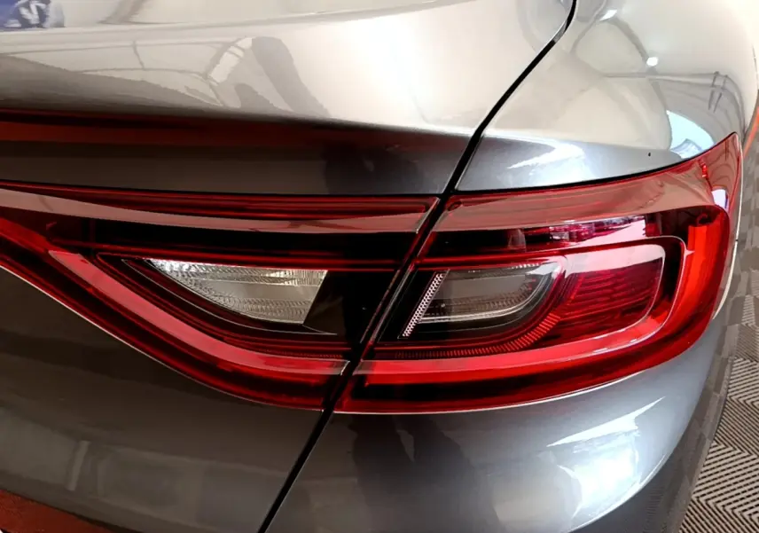 Gros plan sur le feu arrière droit rouge et blanc du Renault Arkana gris clair Evolution E-Tech 2023.