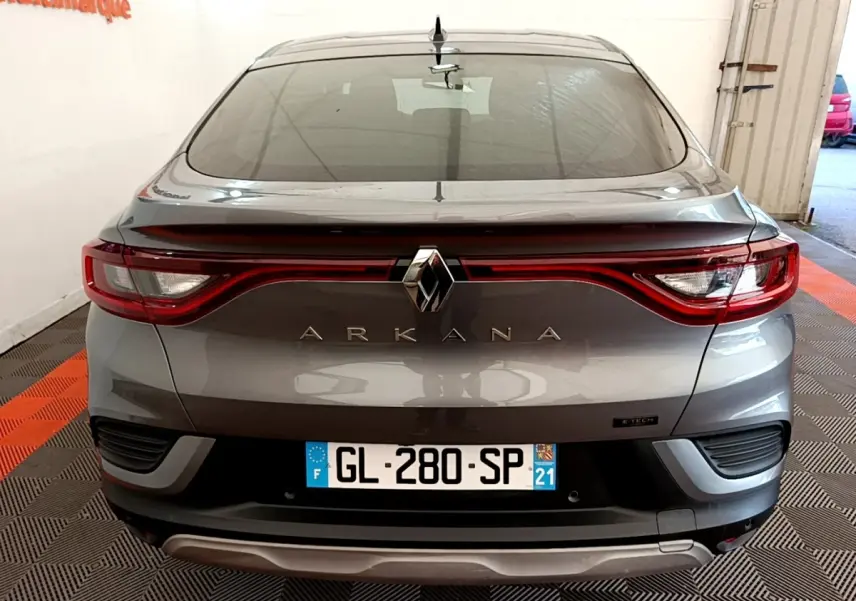 Vue arrière d’une Renault Arkana gris clair avec feux LED reliés et logo central bien visible.