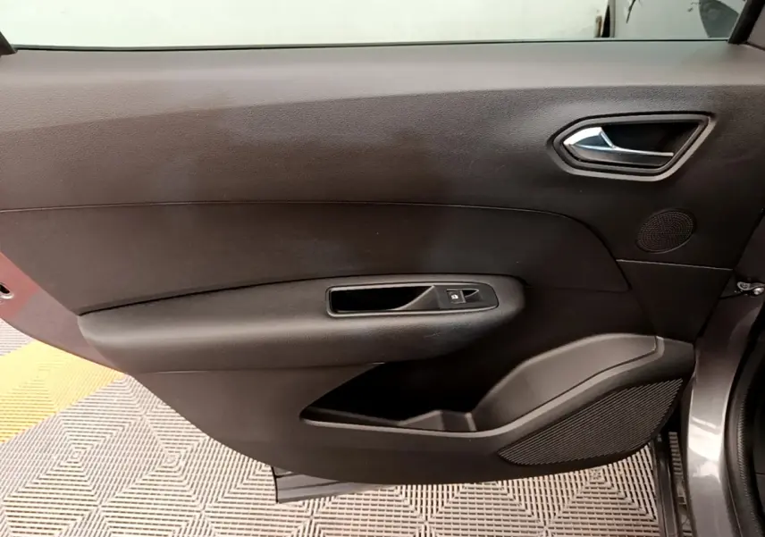 Vue intérieure côté gauche de la porte avant grise du Renault Arkana, avec poignée et commande de fenêtre noire.