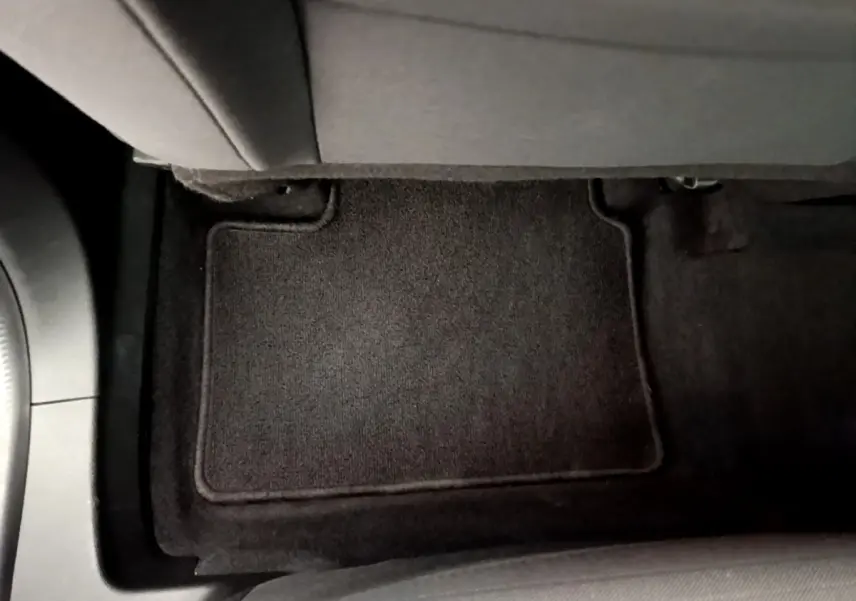 Vue rapprochée du tapis de sol noir côté passager arrière du Renault Arkana gris clair 2023.