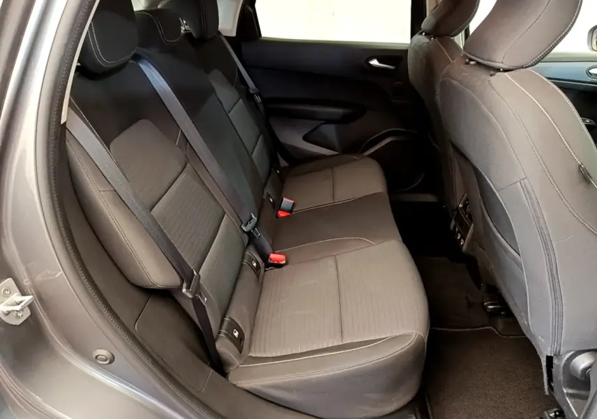 Vue intérieure côté gauche des sièges arrière gris foncé du Renault Arkana Evolution E-Tech 2023 avec ceintures de sécurité visibles.