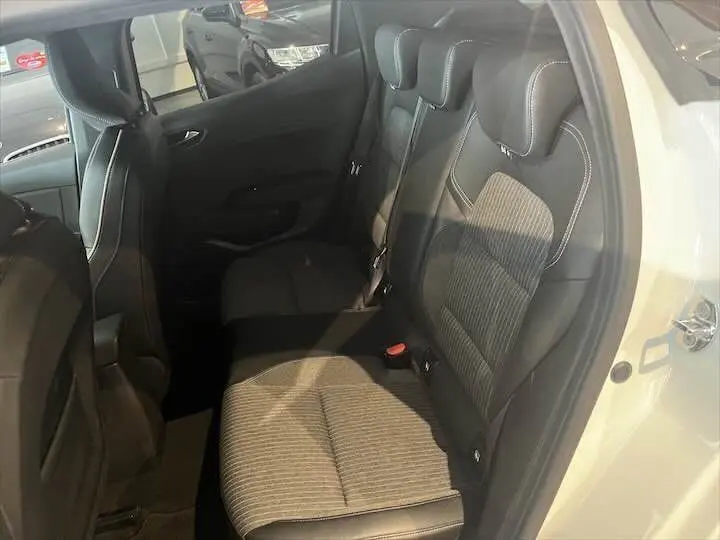 Vue intérieure côté droit montrant la banquette arrière en tissu et cuir d'une Renault Clio V blanc nacré 2021