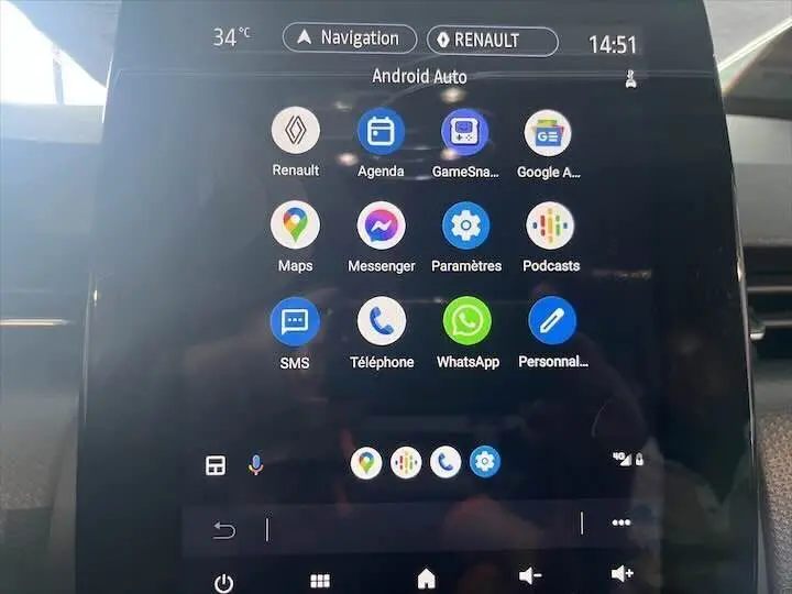 Écran tactile central de la Renault Clio V blanc nacré, affichant l'interface Android Auto avec plusieurs applications.