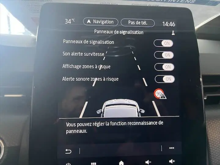 Écran tactile intérieur de la Renault Clio V blanc nacré, affichant les réglages d'alerte et reconnaissance des panneaux.