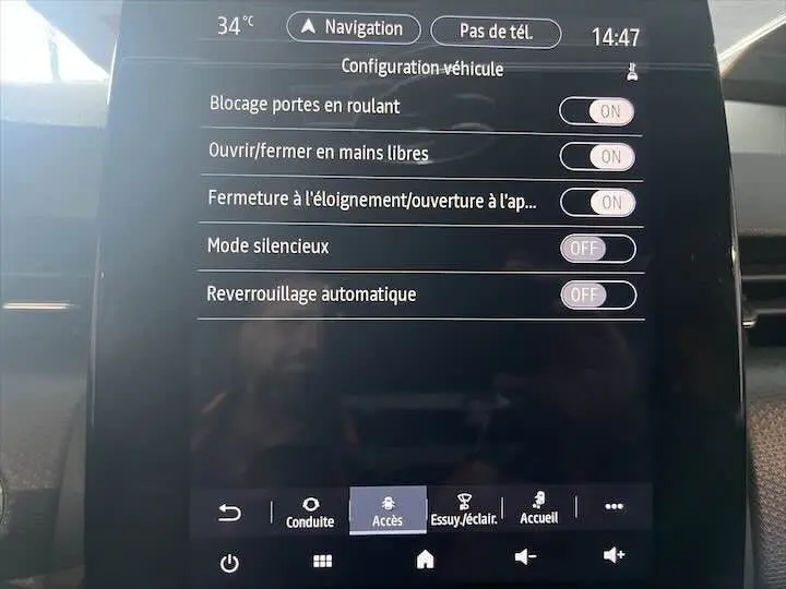 Écran tactile du tableau de bord de la Renault Clio V blanc nacré, affichant les réglages d'accès mains libres et verrouillage.