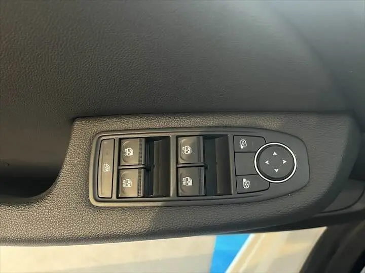 Panneau de commandes des vitres et rétroviseurs côté conducteur d'une Renault Clio V blanc nacré métal, intérieur noir.