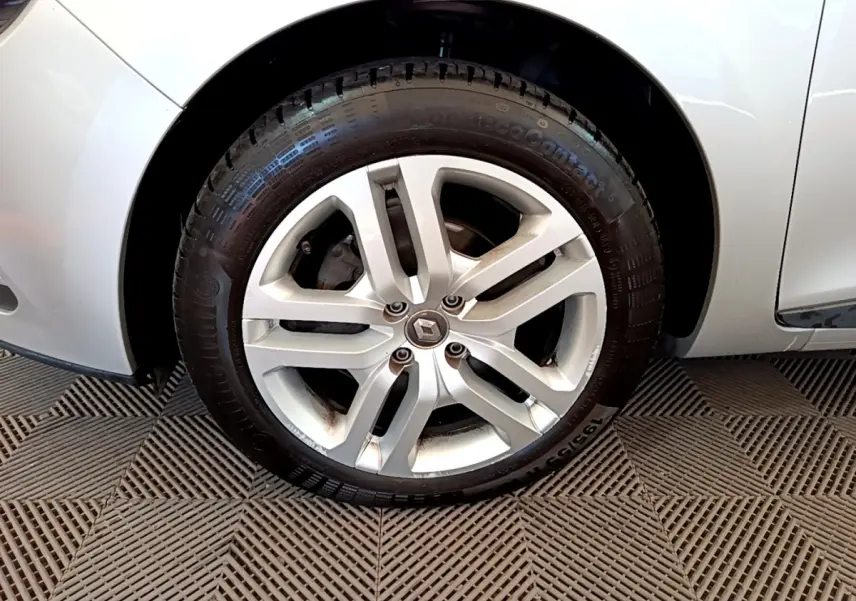 Gros plan sur la roue avant gauche gris clair d'une Renault Clio Business TCe 90 avec jante alliage à 5 branches doubles.