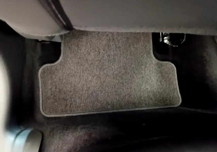 Vue rapprochée du tapis de sol gris clair côté conducteur d'une Renault Clio Business TCe 90 essence 2019.