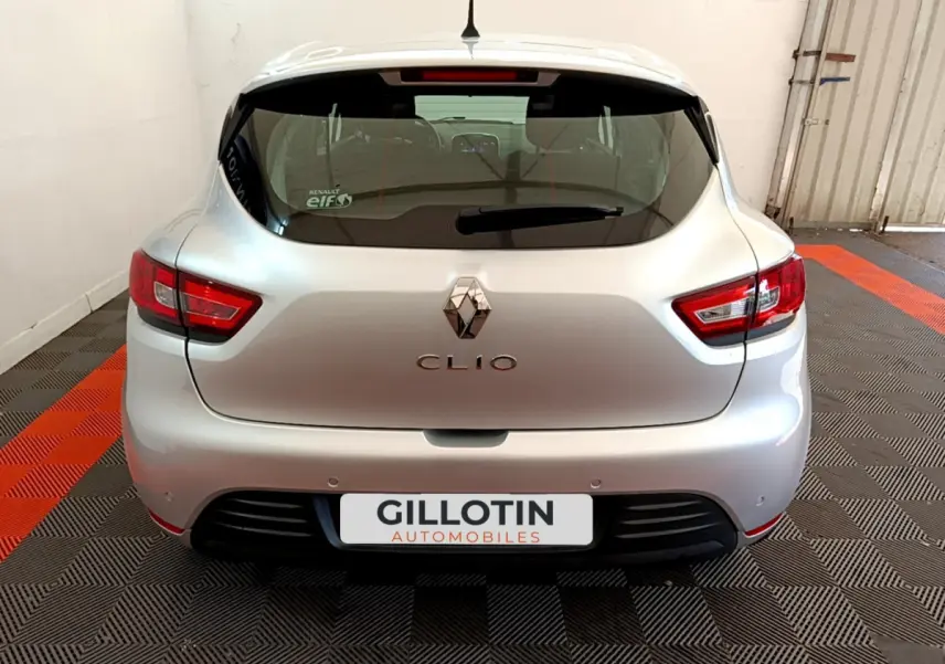 Vue arrière d'une Renault Clio Business TCe 90 gris clair garée sur un sol à damiers noir et orange dans un garage.