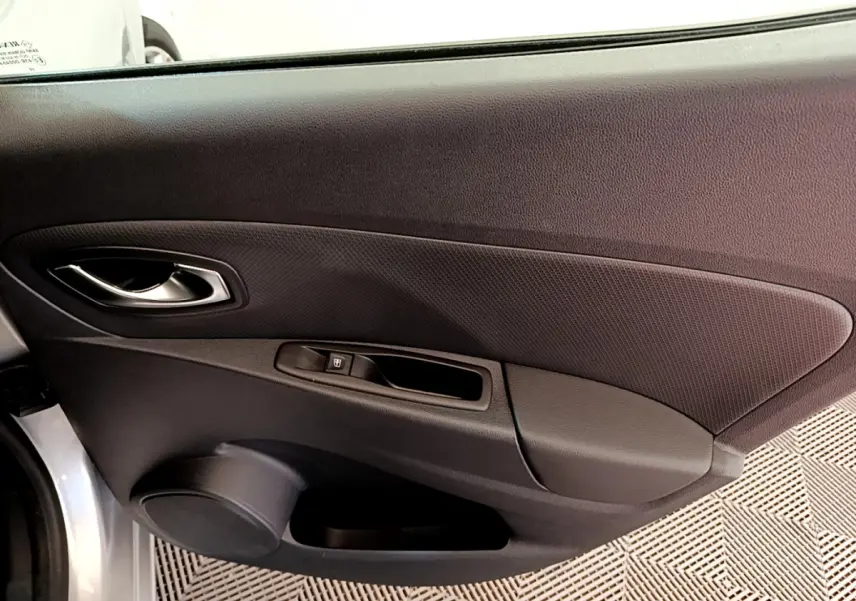 Gros plan sur la porte côté gauche d'une Renault Clio Business gris clair, avec poignée argentée et commande de vitre électrique.