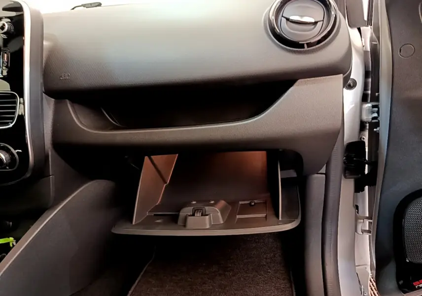 Gros plan sur la boîte à gants ouverte côté passager d'une Renault Clio Business TCe 90 gris clair, intérieur noir.