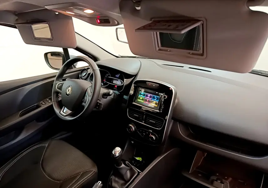 Intérieur de Renault Clio Business TCe 90 2019, vue côté conducteur, tableau de bord avec écran tactile et volant cuir.