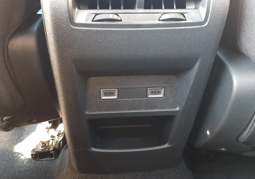 Détail des ports USB arrière et bouches d'aération sur console centrale noire d'une Peugeot 308 Bleu Obsession 2025.