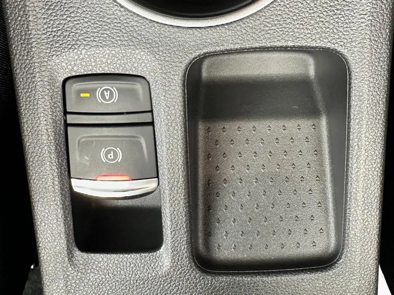 Gros plan sur les commandes de frein de stationnement électrique et arrêt auto du Renault Captur 1.6 E-Tech hybride 2025, intérieur noir.