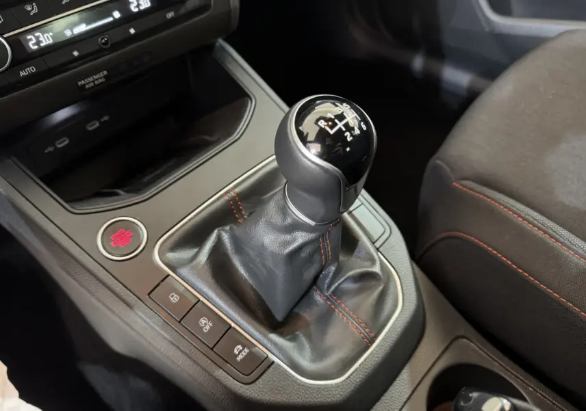 Le levier de vitesses manuel noir avec surpiqûres rouges de la SEAT IBIZA 1.0 TSI 110 FR vue en gros plan intérieur.
